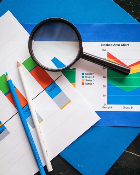Image of financial charts and magnifying glass, ideal for business insights.